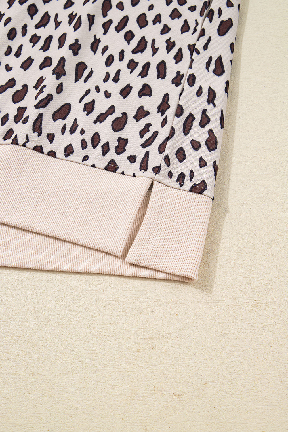 Leopard print fabric with beige ribbed hem and side slit detail