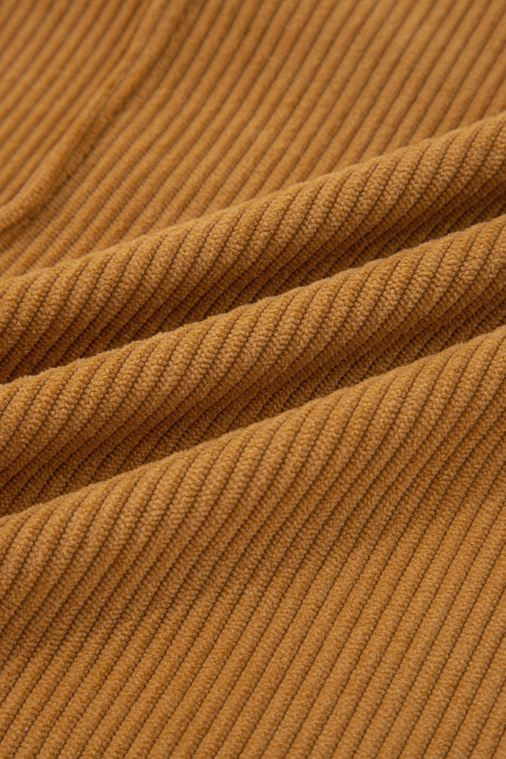 Close-up of brown ribbed corduroy fabric texture, soft textile material