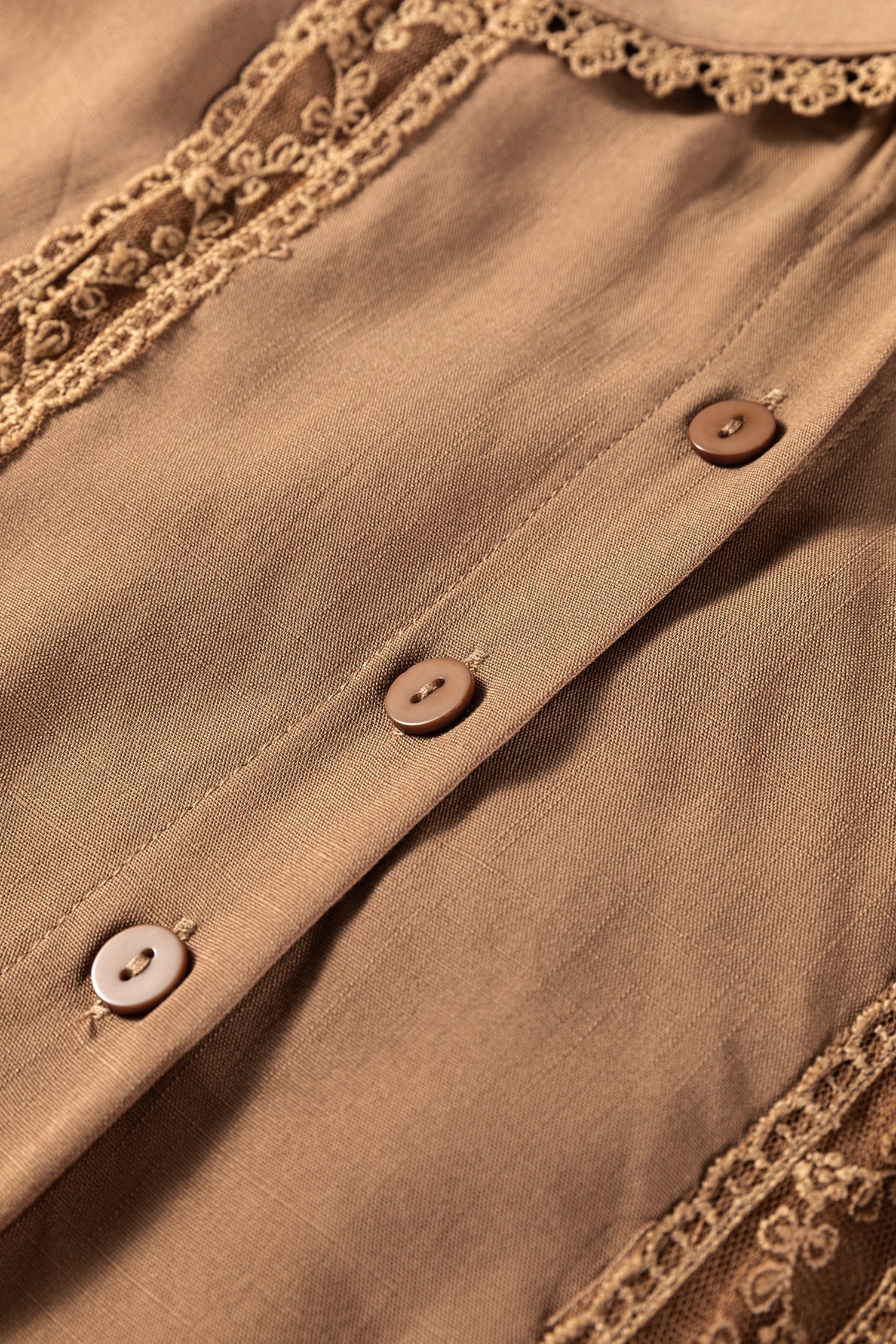 Close-up of a brown blouse with buttons and lace trim detail