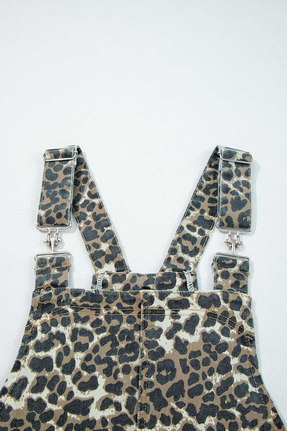Leopard print denim overalls with adjustable straps, animal print fashion detail