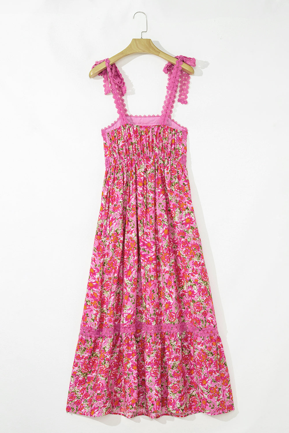Pink floral sleeveless maxi dress with lace trim and tie straps on hanger