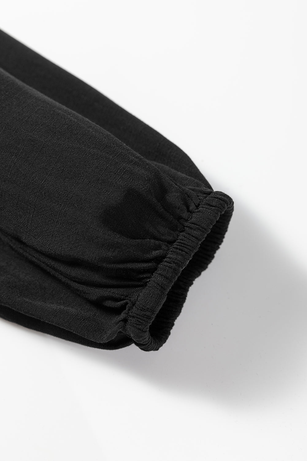 Black fabric sleeve with elastic cuff on white background