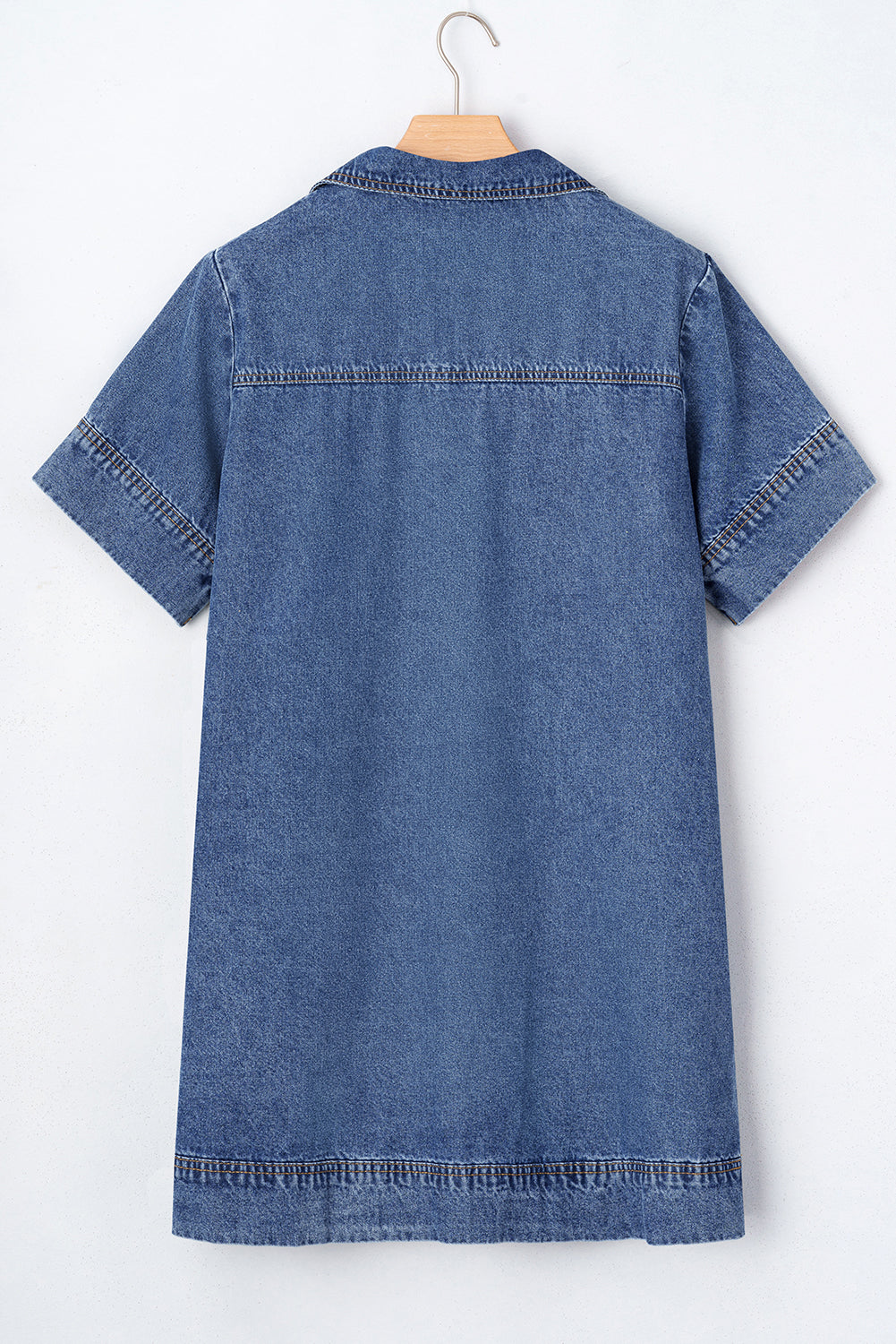 Back view of short sleeve denim dress with collar and visible seams, hanging on hanger