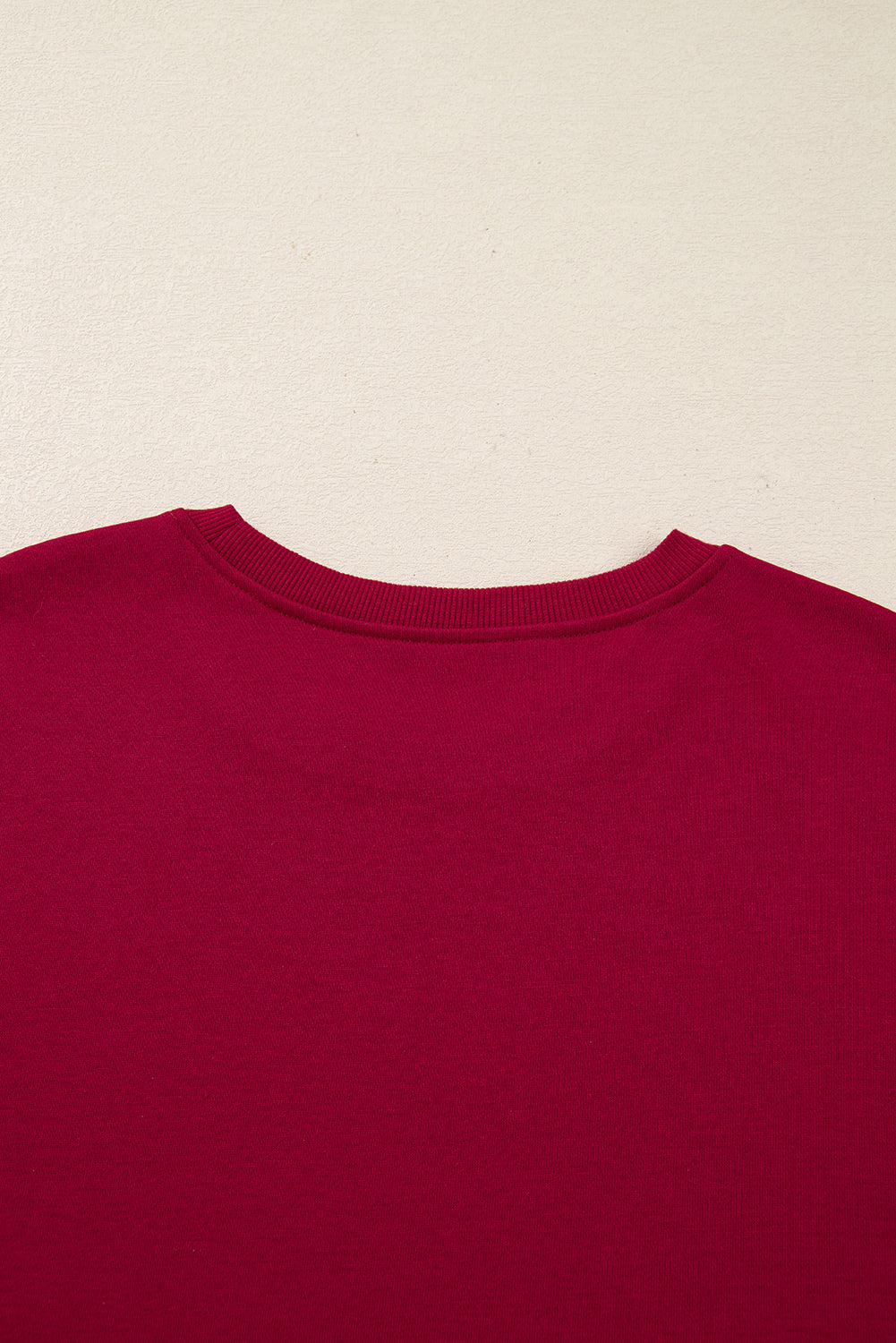 Close-up of a red crew neck sweatshirt on a light background