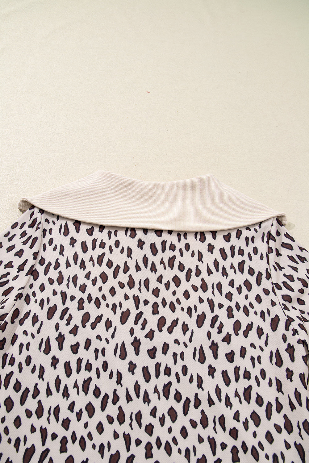 Beige collar top with brown and black animal print pattern, close-up back view