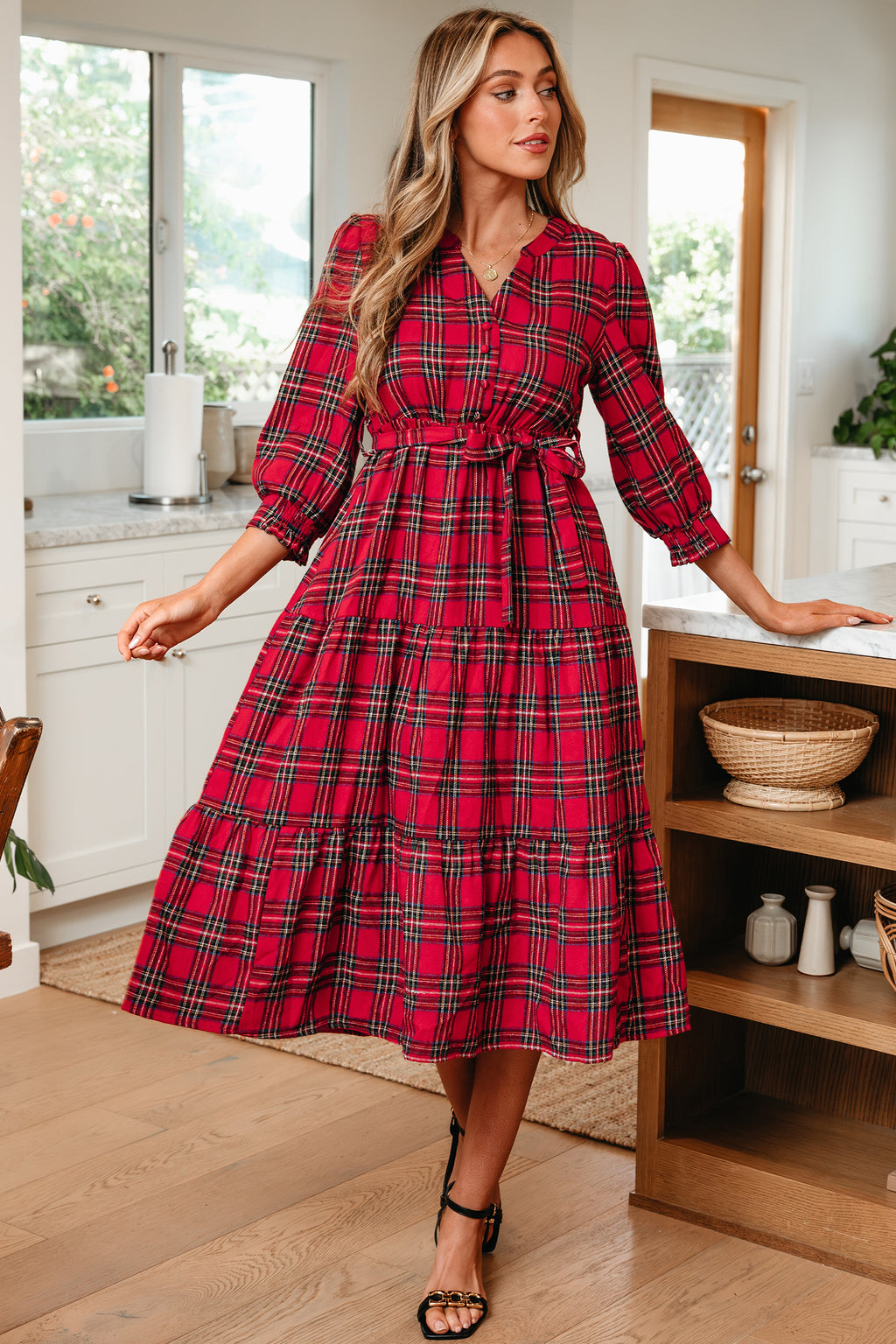 Woman wearing a red plaid midi dress with long sleeves in a modern kitchen