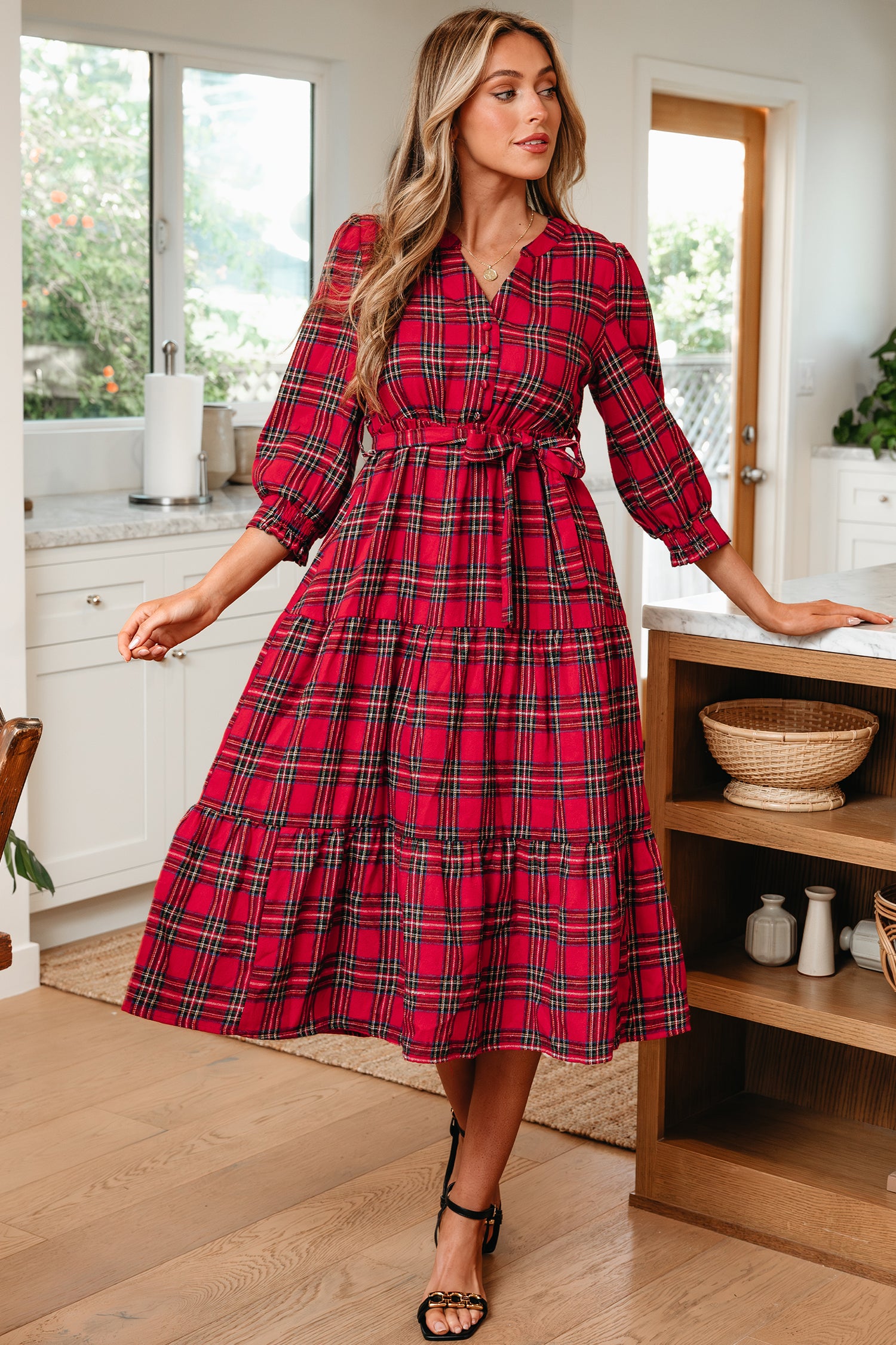 Woman wearing a red plaid midi dress with long sleeves in a modern kitchen