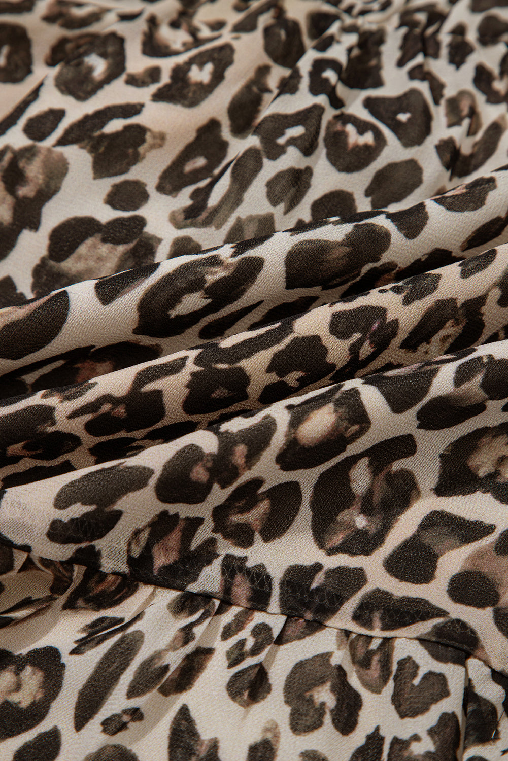 close-up of beige and brown leopard print fabric texture, animal print textile pattern