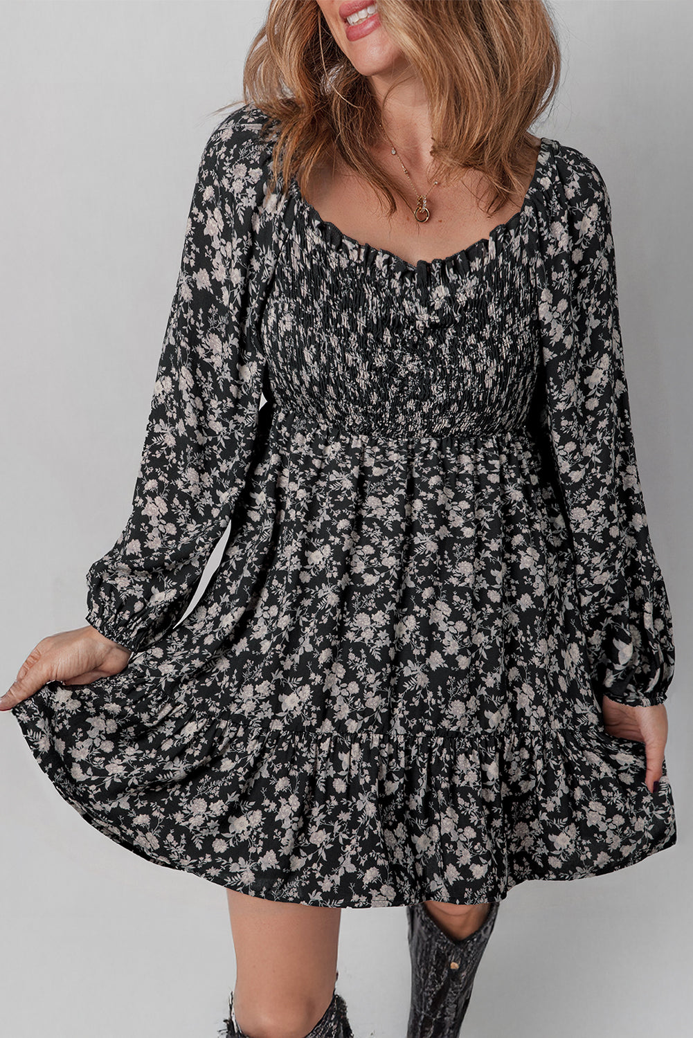 Woman wearing a long sleeve black floral mini dress with ruffled hem