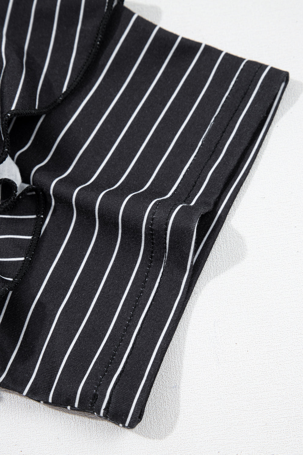 Close-up of black and white pinstripe fabric with clean stitching detail