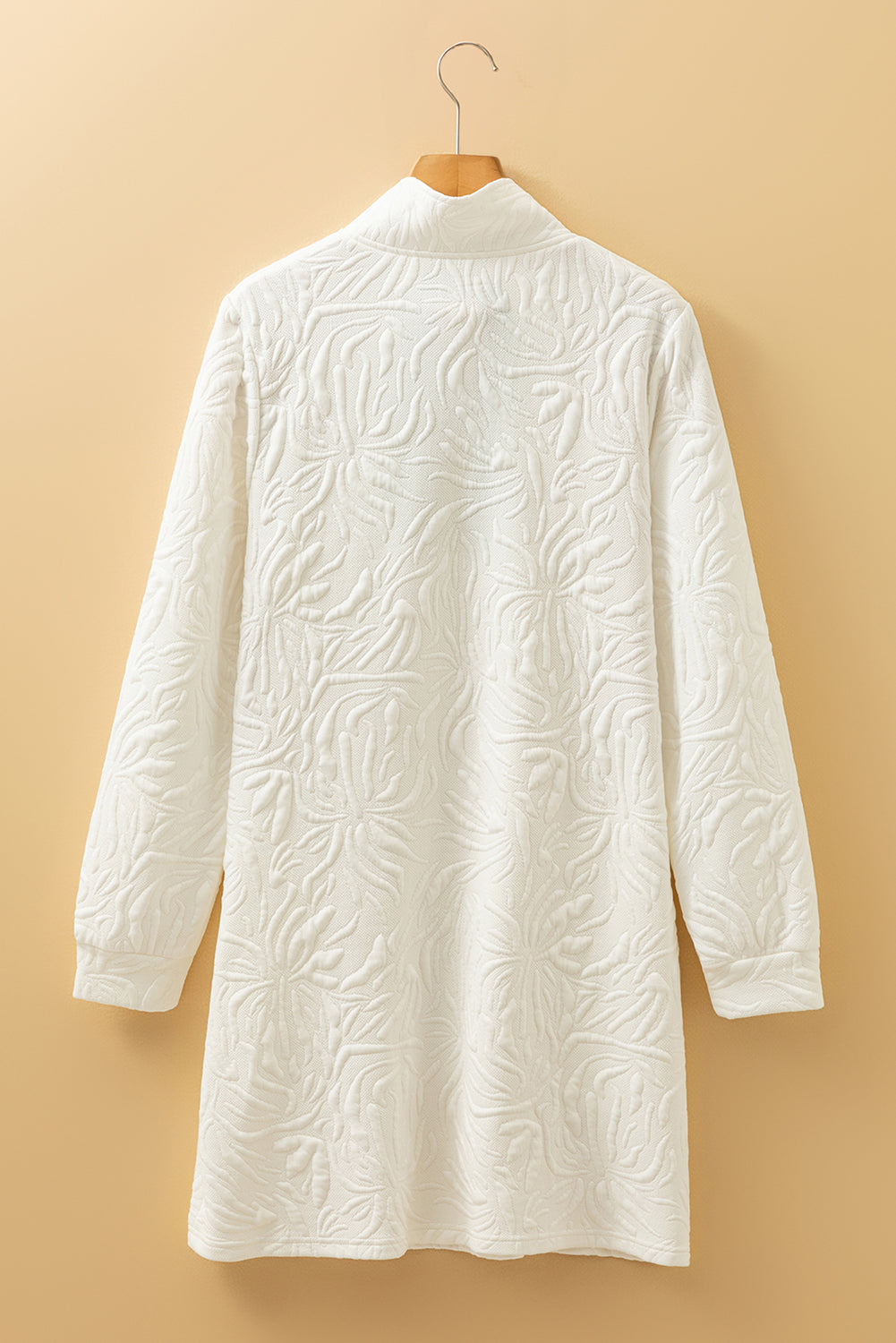 Textured white long sleeve coat with floral pattern on beige background