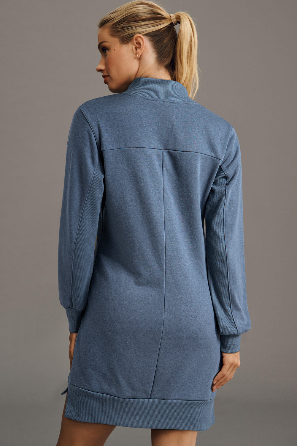 Woman in blue long-sleeve sweater dress, back view, casual fashion