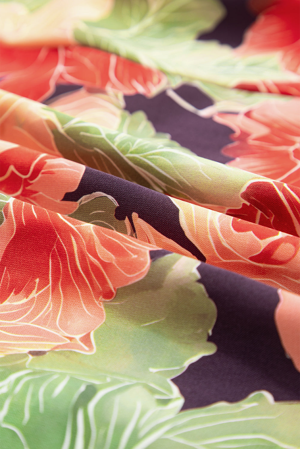 Close-up of floral fabric with red flowers and green leaves on dark background
