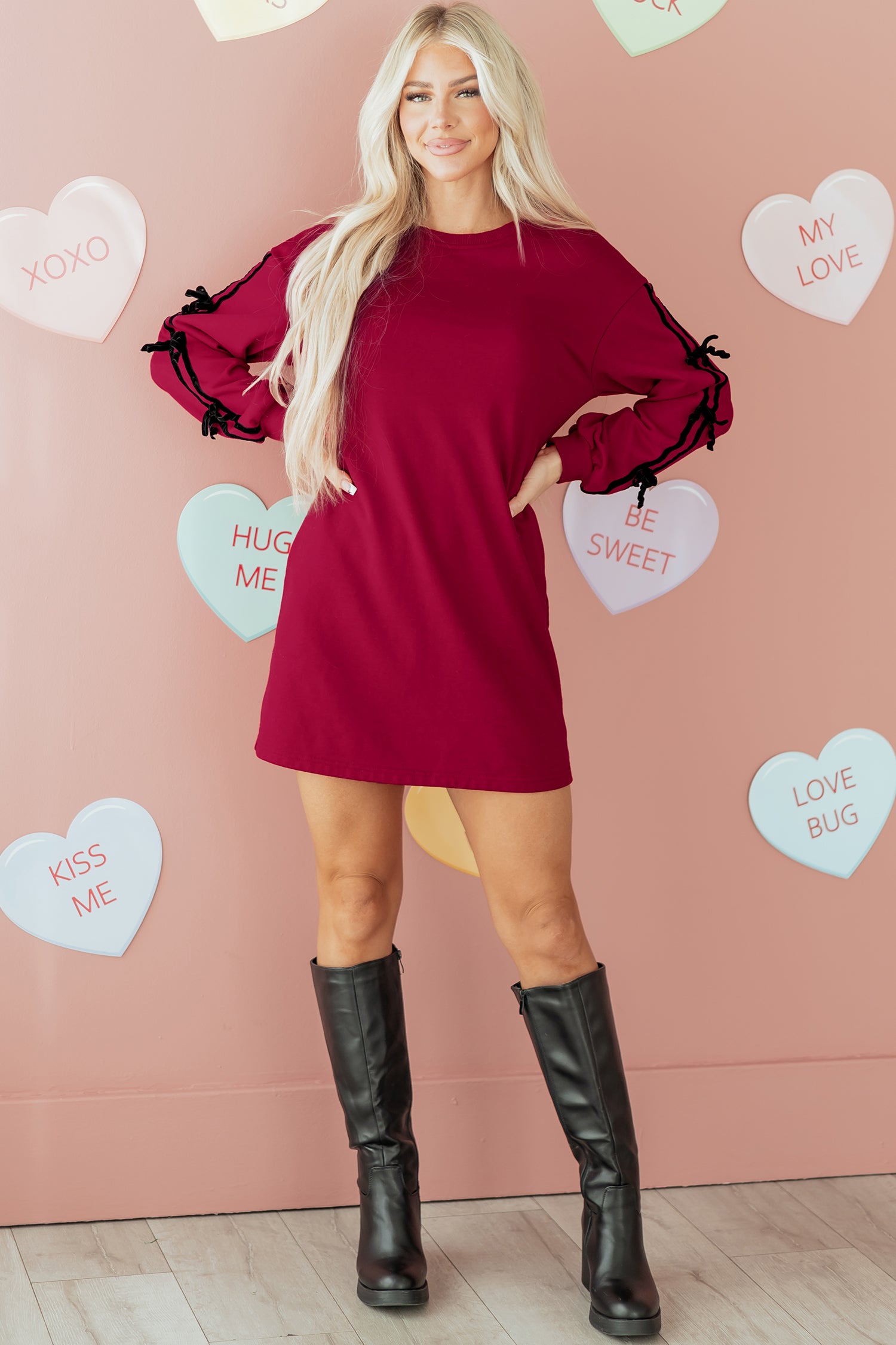 Woman in red long sleeve dress with black boots, Valentine heart wall decor background