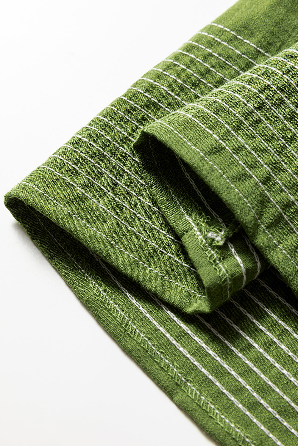 Green linen fabric with white vertical stripes, close-up of folded hem
