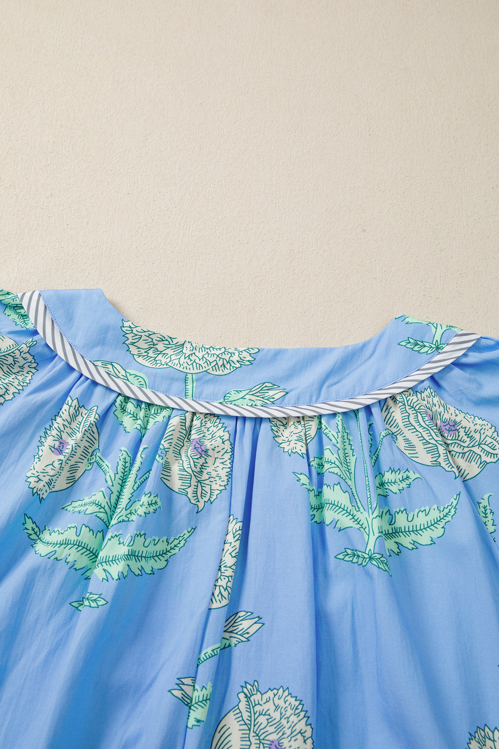 Детайл на набора под деколтето на синя рокля