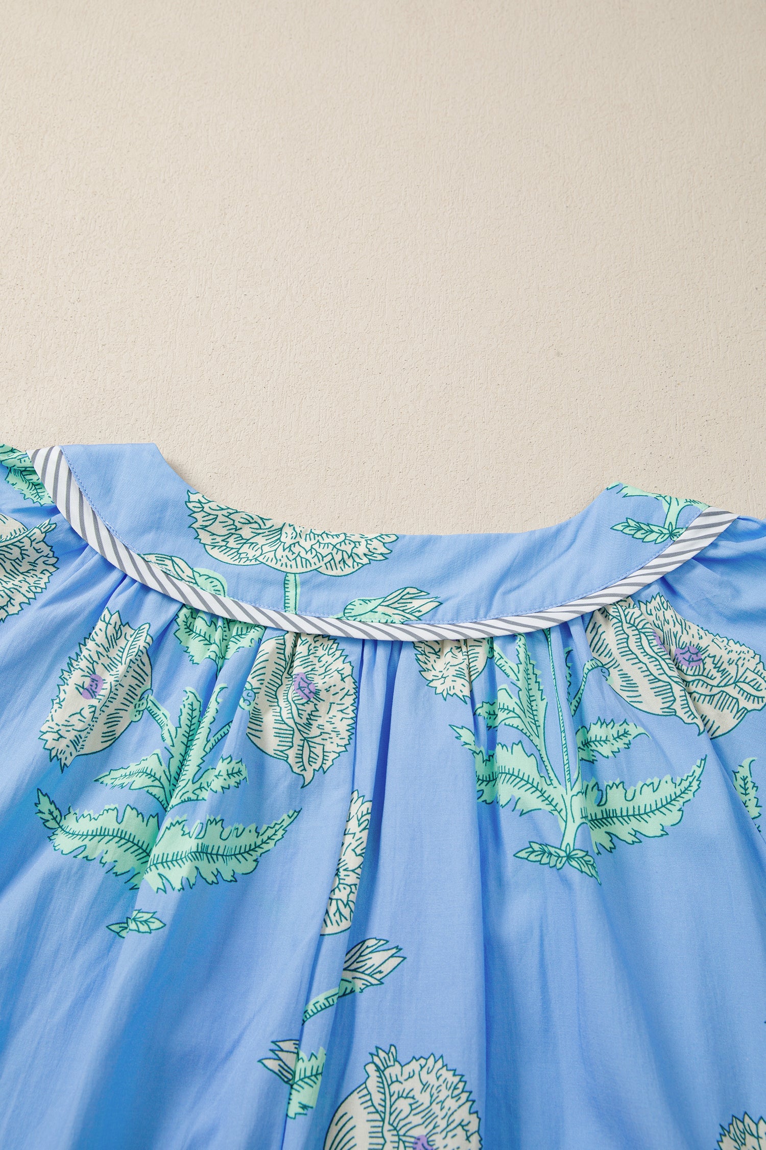 Детайл на набора под деколтето на синя рокля