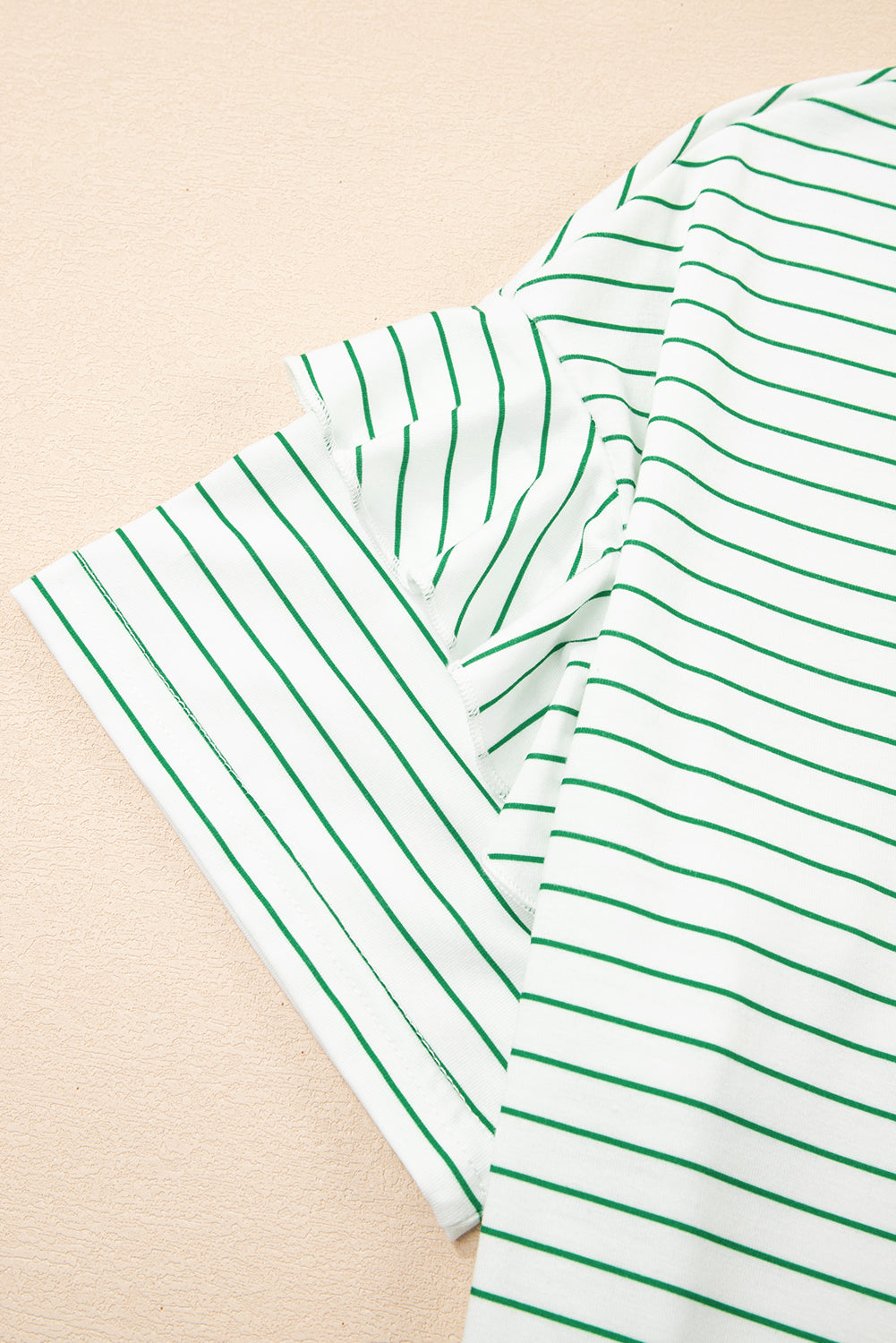 White T-shirt with green stripes, close-up of short sleeve and fabric texture
