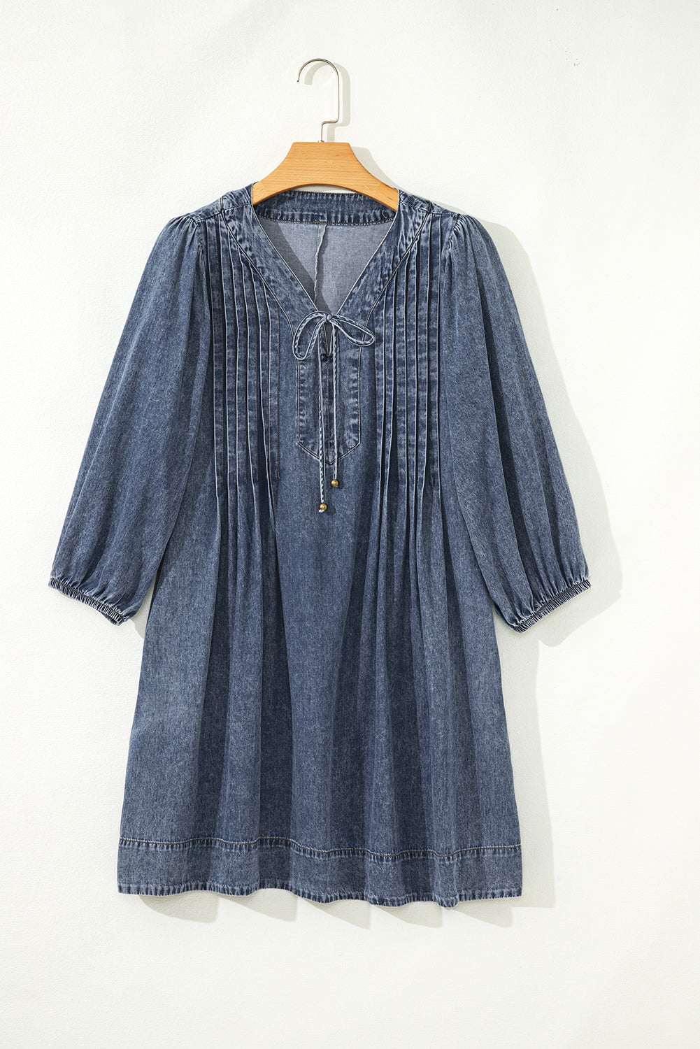 Denim mini dress with pleated front, V-neckline and long sleeves on hanger