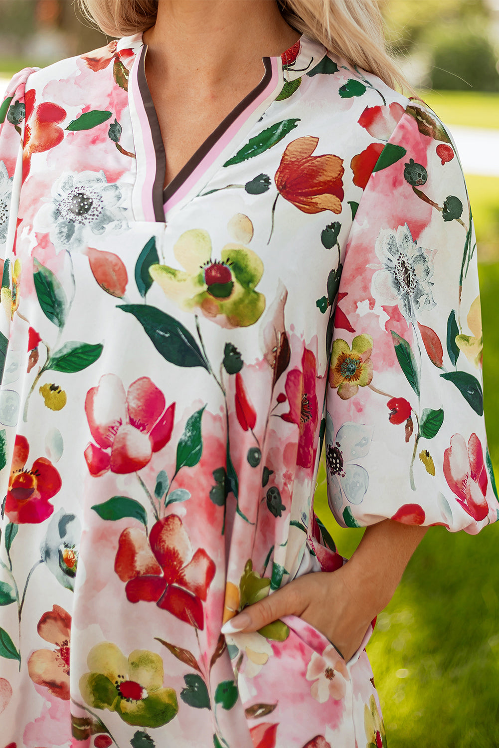 Woman wearing a white floral dress with colorful watercolor flower print and short sleeves