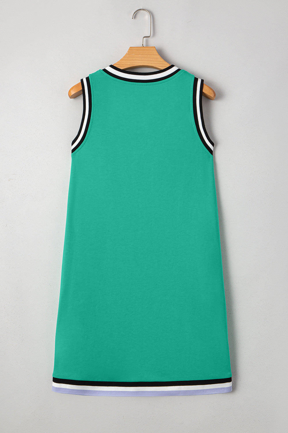 Sleeveless green dress with black and white trim on collar and hem, hanging on wooden hanger