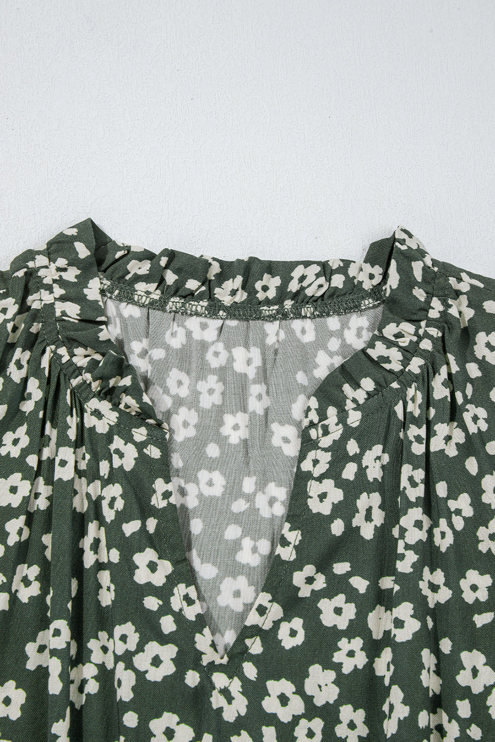 Green floral V-neck dress with small white flower pattern and ruffle collar detail