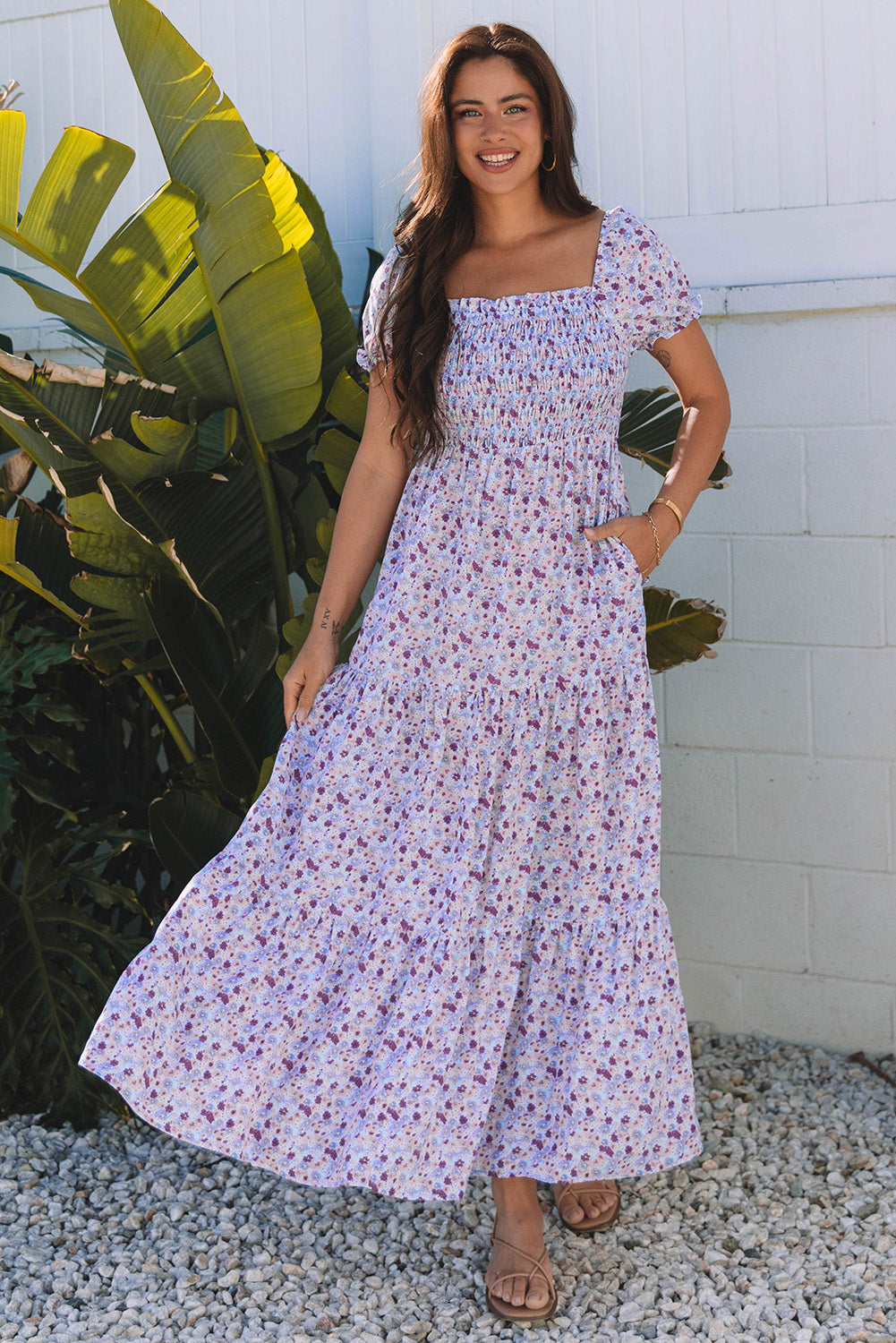 Woman outdoors in a long, floral maxi dress with short sleeves and smocked bodice