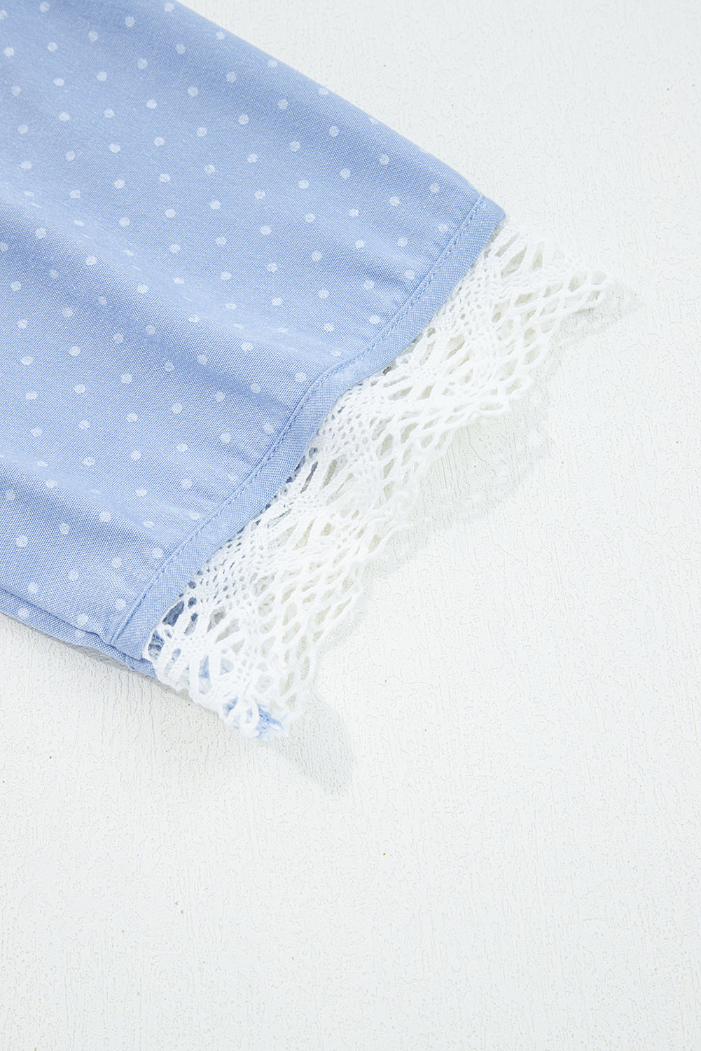 детайл на ръкав с дантелен завършек на дамска блуза от лек деним