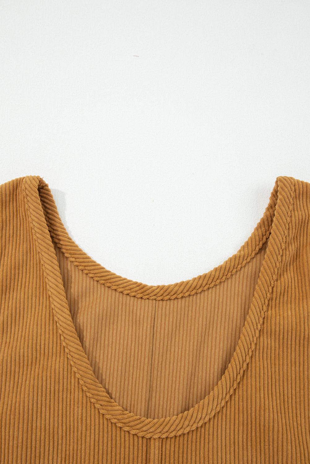 Close-up of ribbed brown tank top neckline on white background