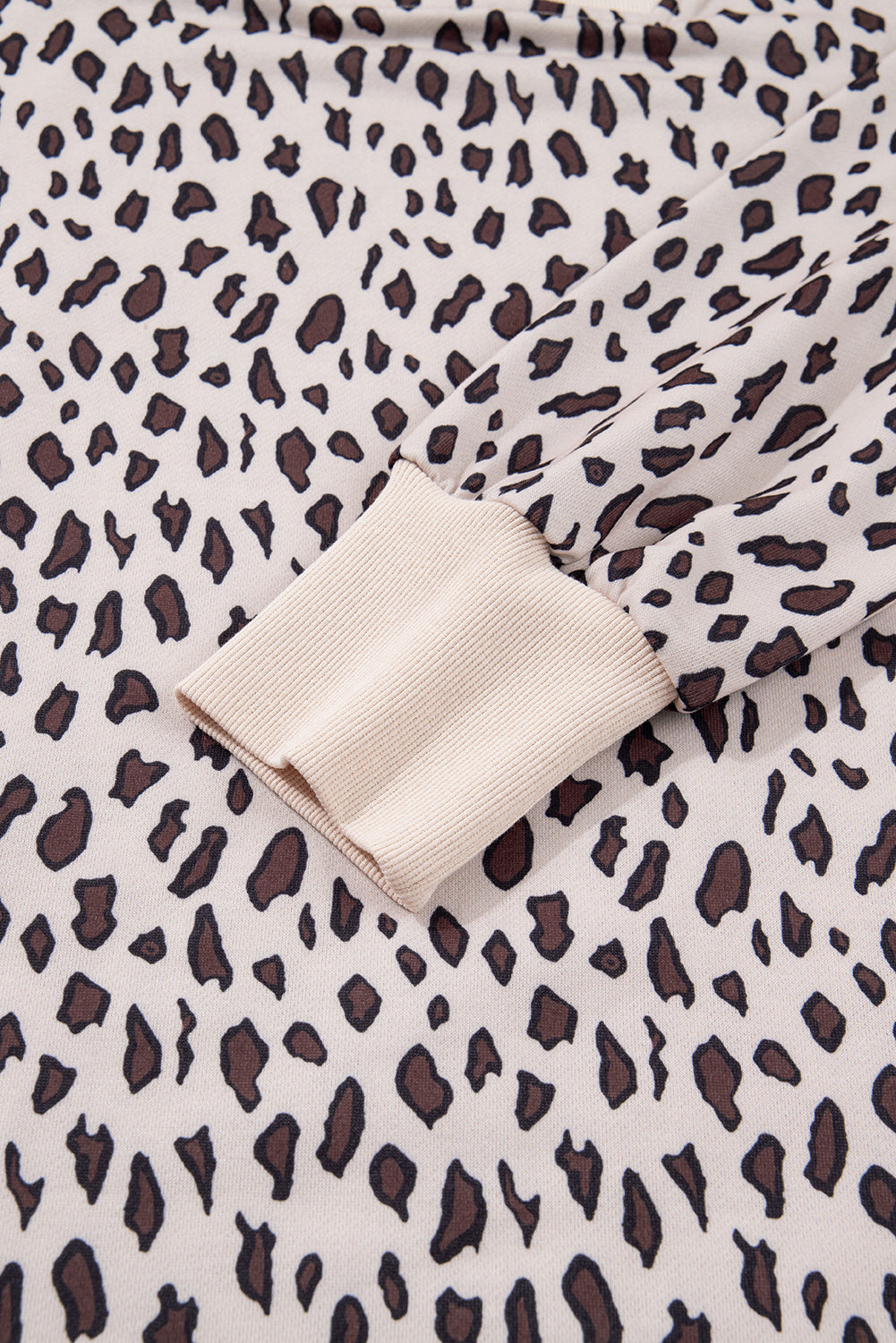 Close-up of beige long sleeve with brown leopard print and ribbed cuff