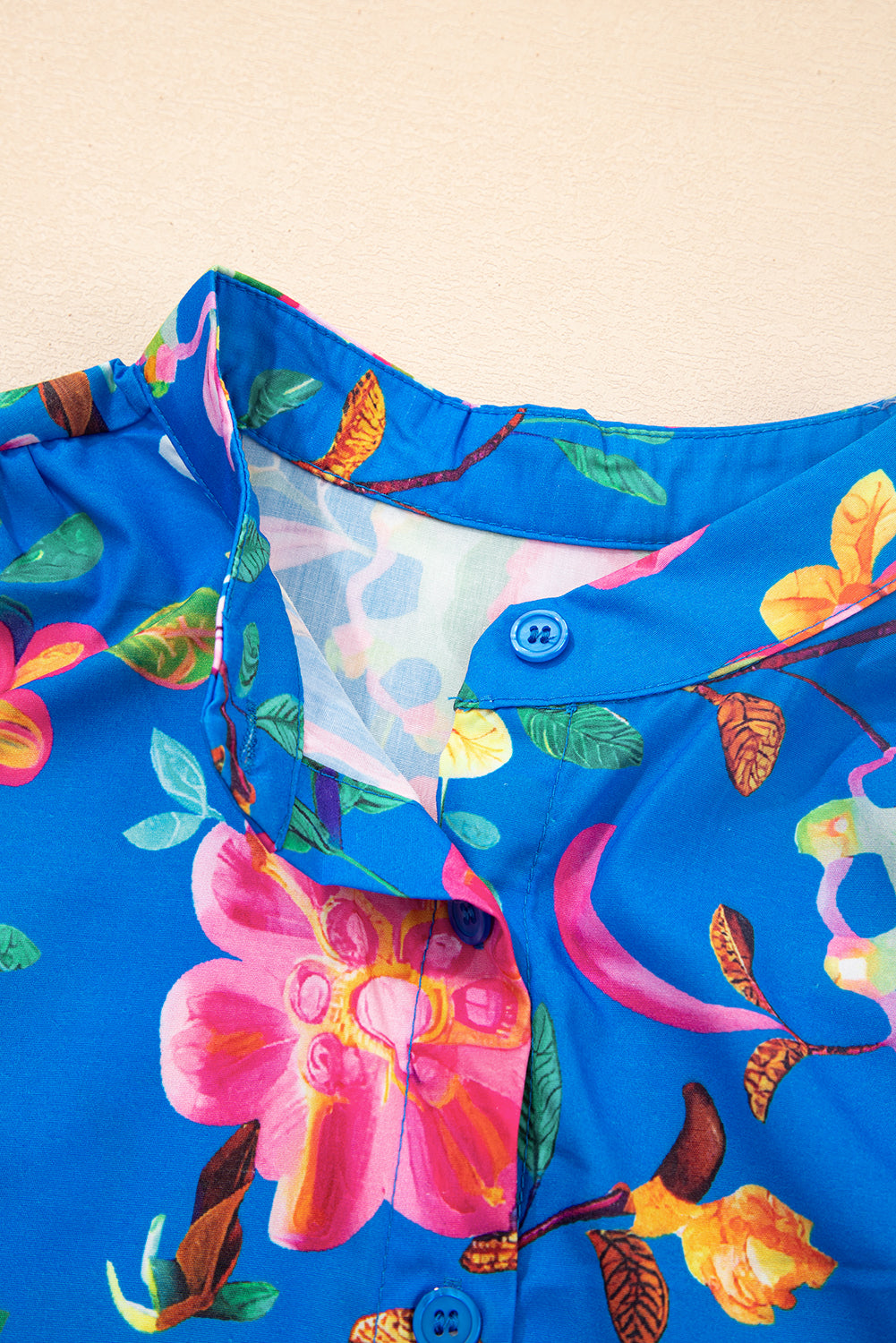 Детайл на яката на синя дамска риза с флорален принт