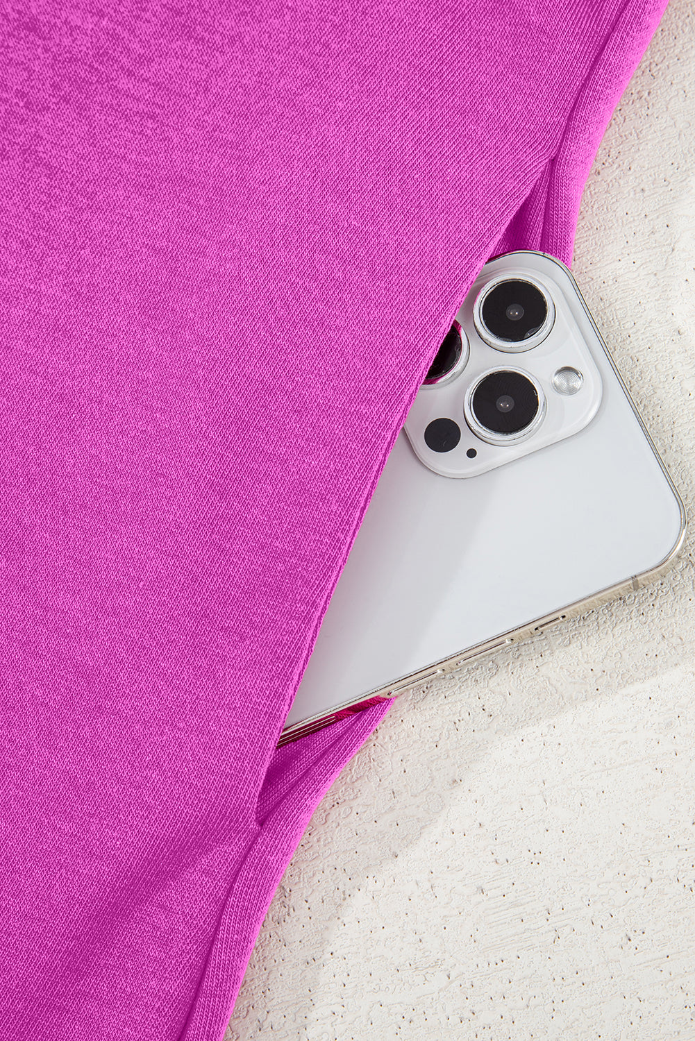 Smartphone in pink fabric pocket, close-up, modern clothing with phone pocket feature