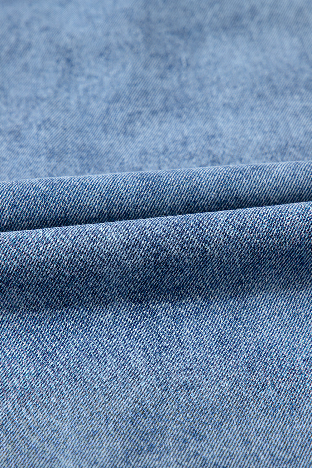 close-up of light blue denim fabric with visible texture and weave pattern