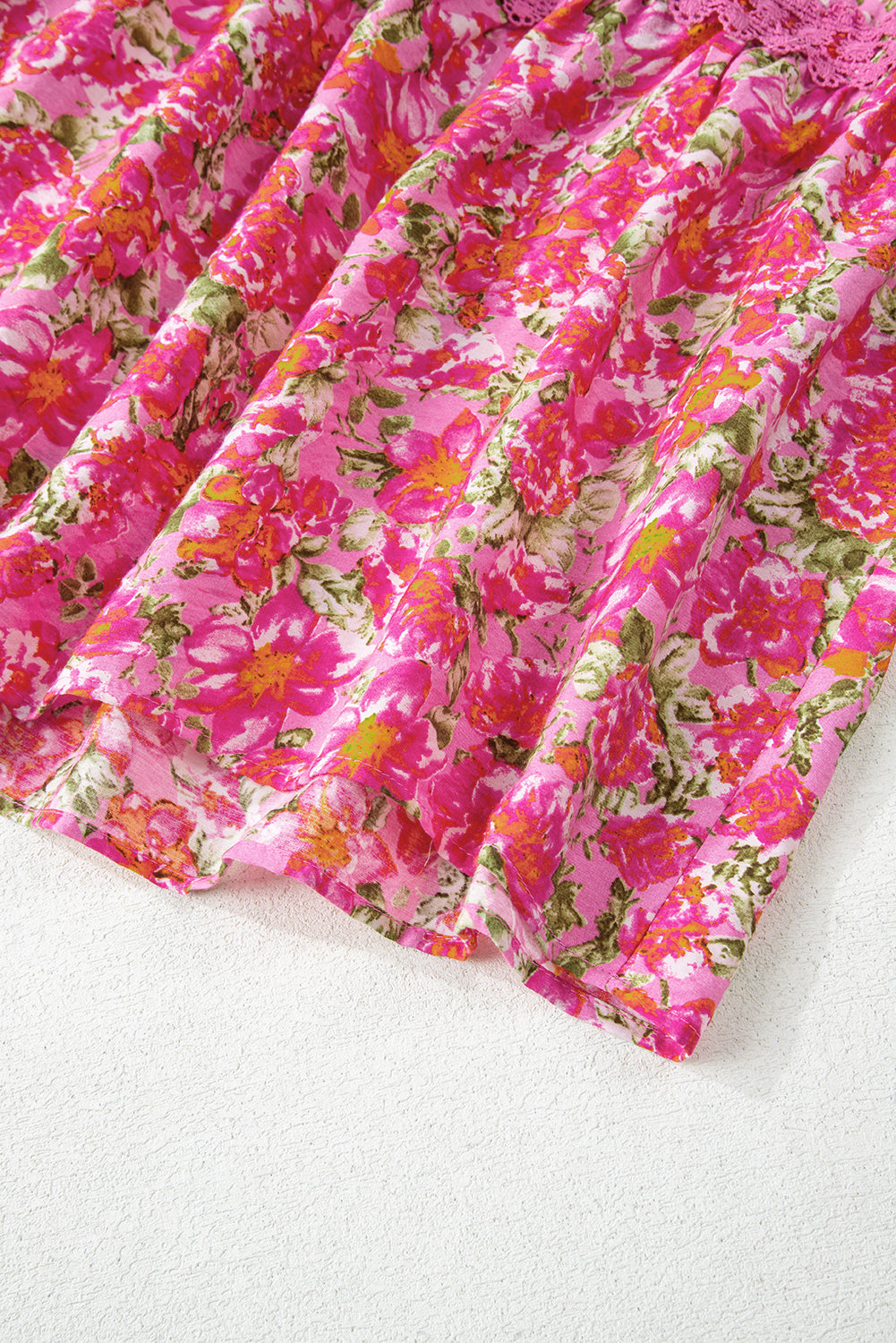 Pink floral print dress fabric with lace trim, vibrant summer floral pattern