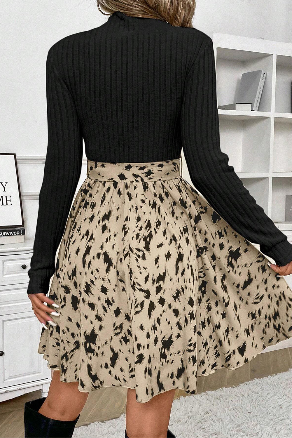 Woman wearing a black ribbed long sleeve top and beige animal print midi skirt