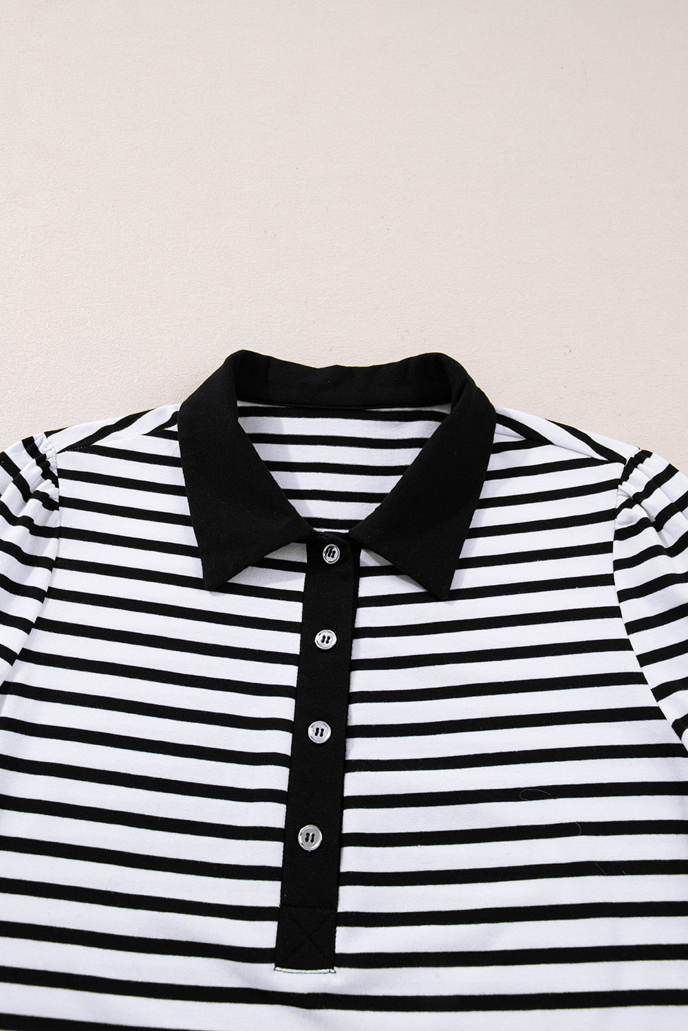 Black and white striped polo shirt with black collar and button placket