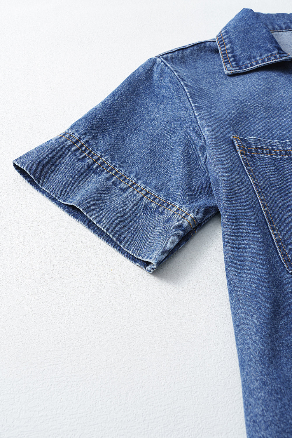 Short sleeve blue denim shirt with front pocket and visible stitching details
