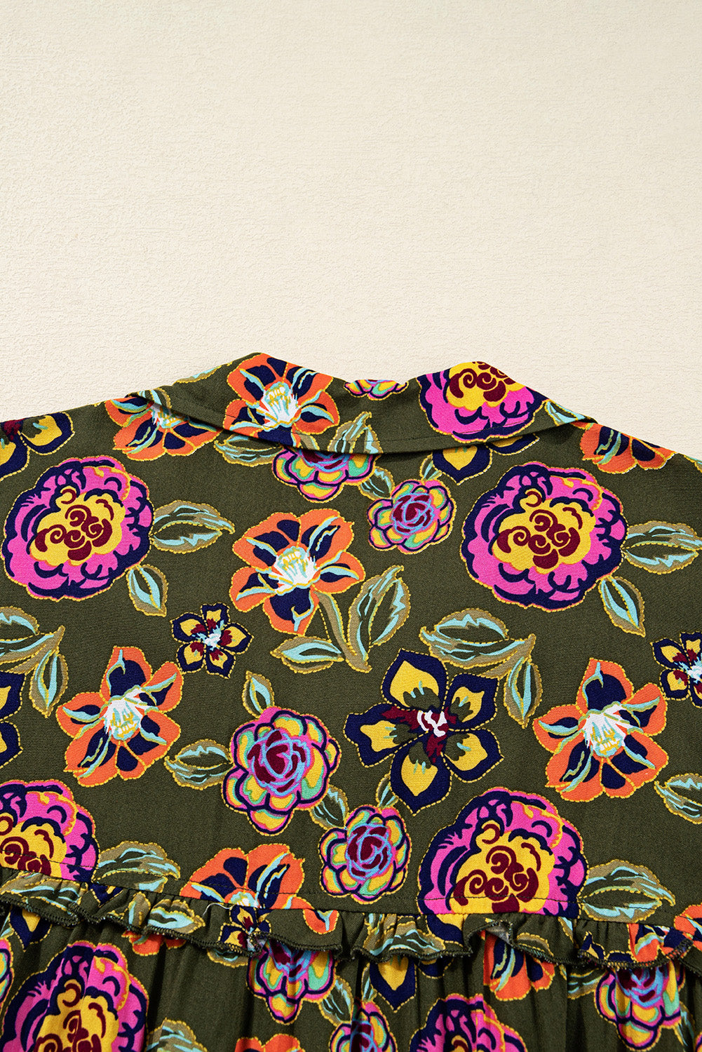 Close-up of floral print fabric with colorful flowers on an olive green background, women's fashion
