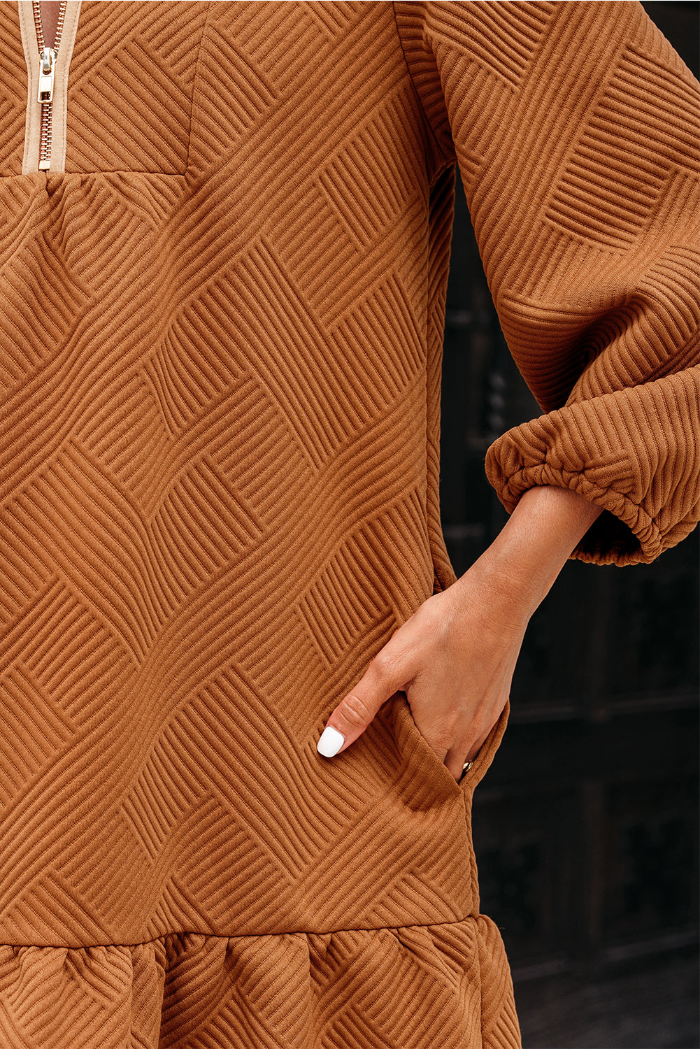 Textured brown dress with geometric pattern, visible sleeve and pocket detail