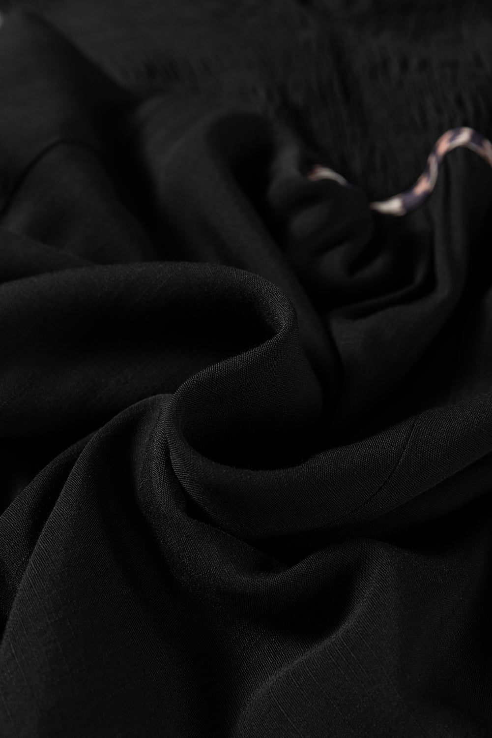 Close-up of soft black fabric with smooth texture and subtle fold details