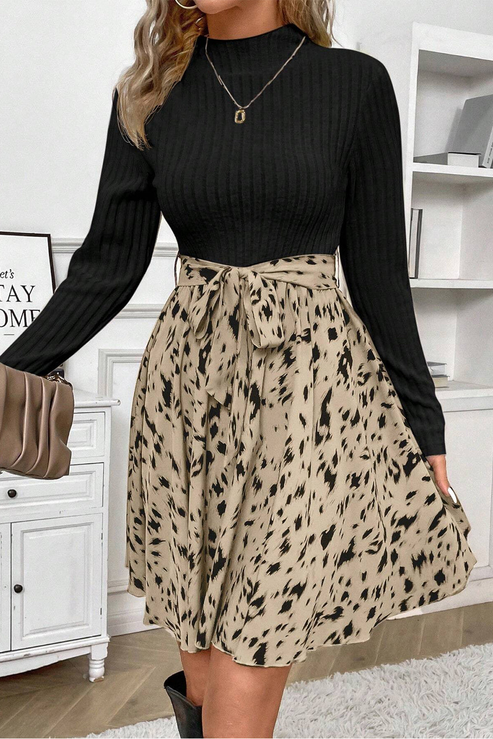 Woman wearing black ribbed sweater and beige leopard print skirt with bow tie waist