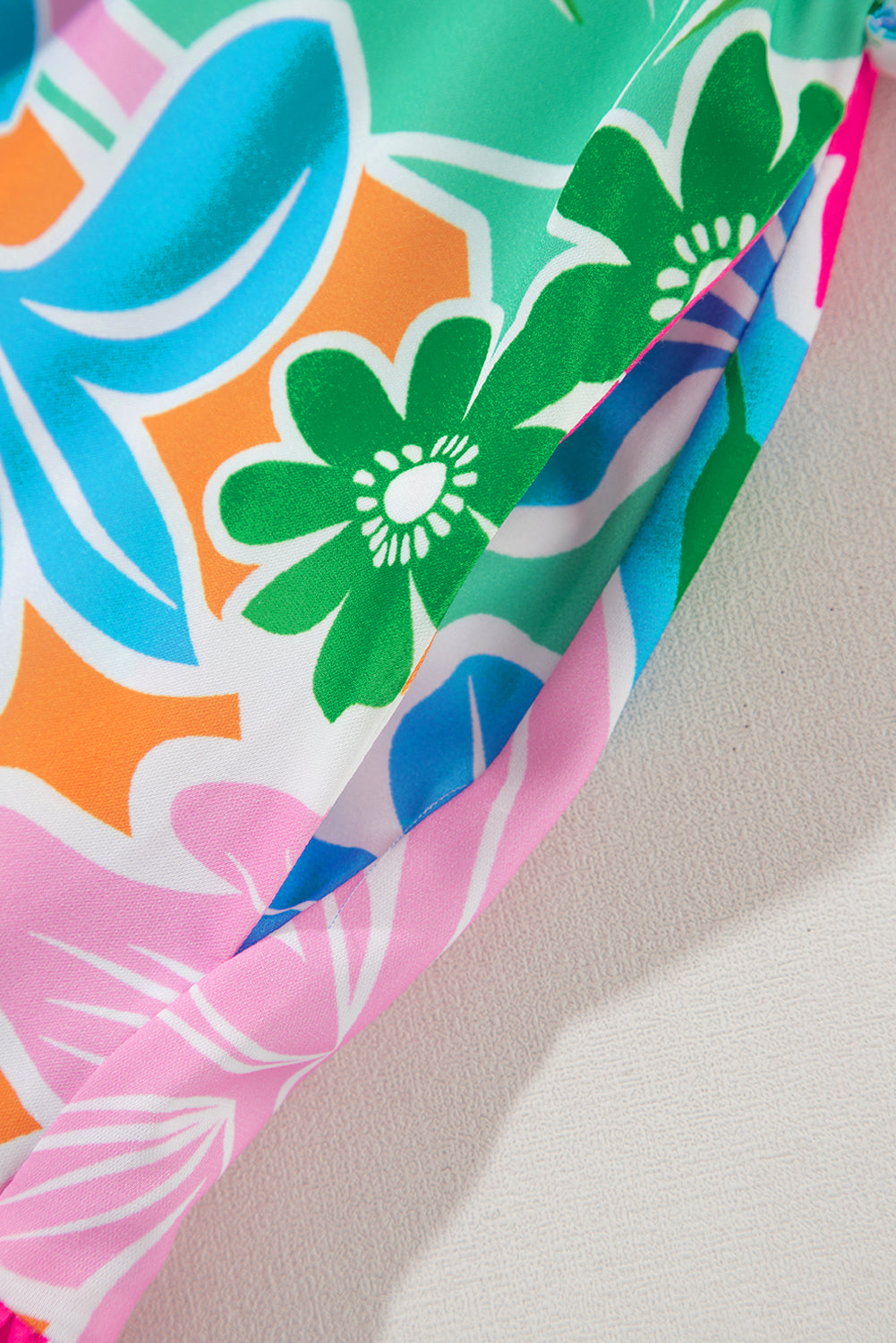 Close-up of colorful floral fabric with green, blue, orange and pink patterns