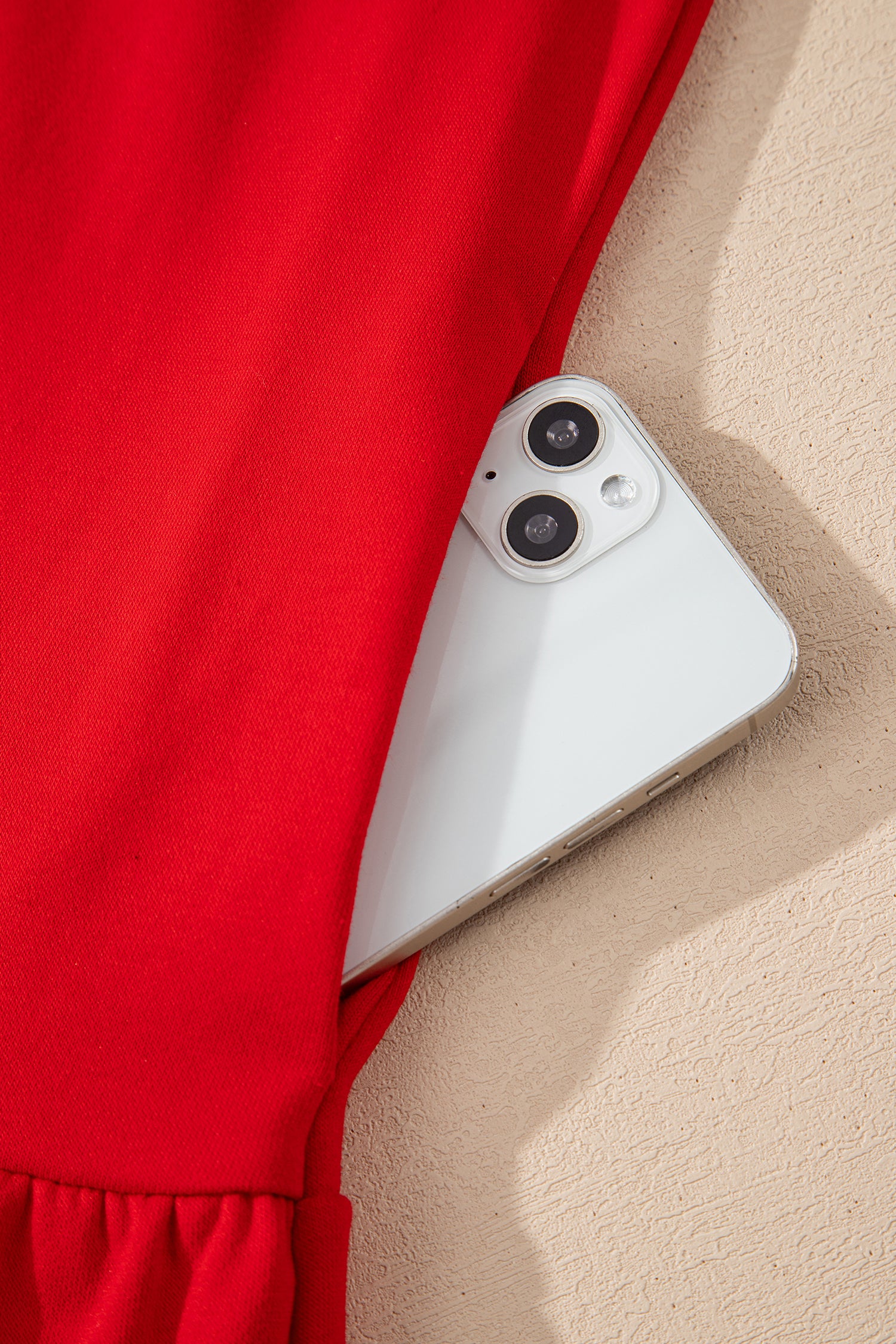 White smartphone in red pocket, stylish tech accessory flat lay