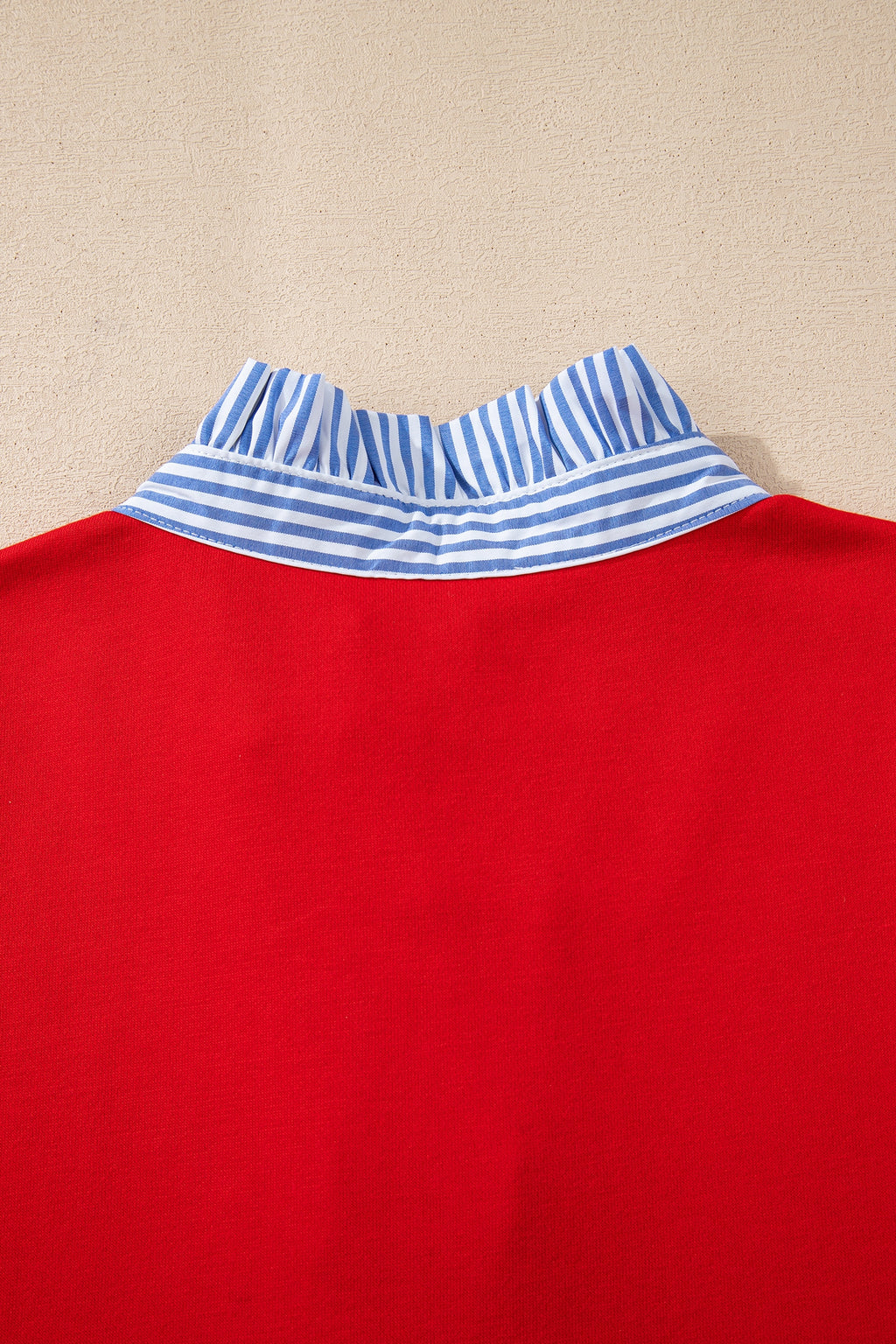 Red top with blue and white striped ruffle collar detail, close-up back view