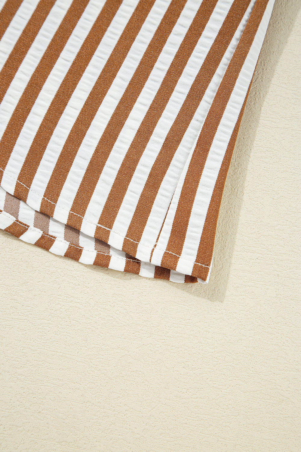 Brown and white vertical striped fabric detail on light background