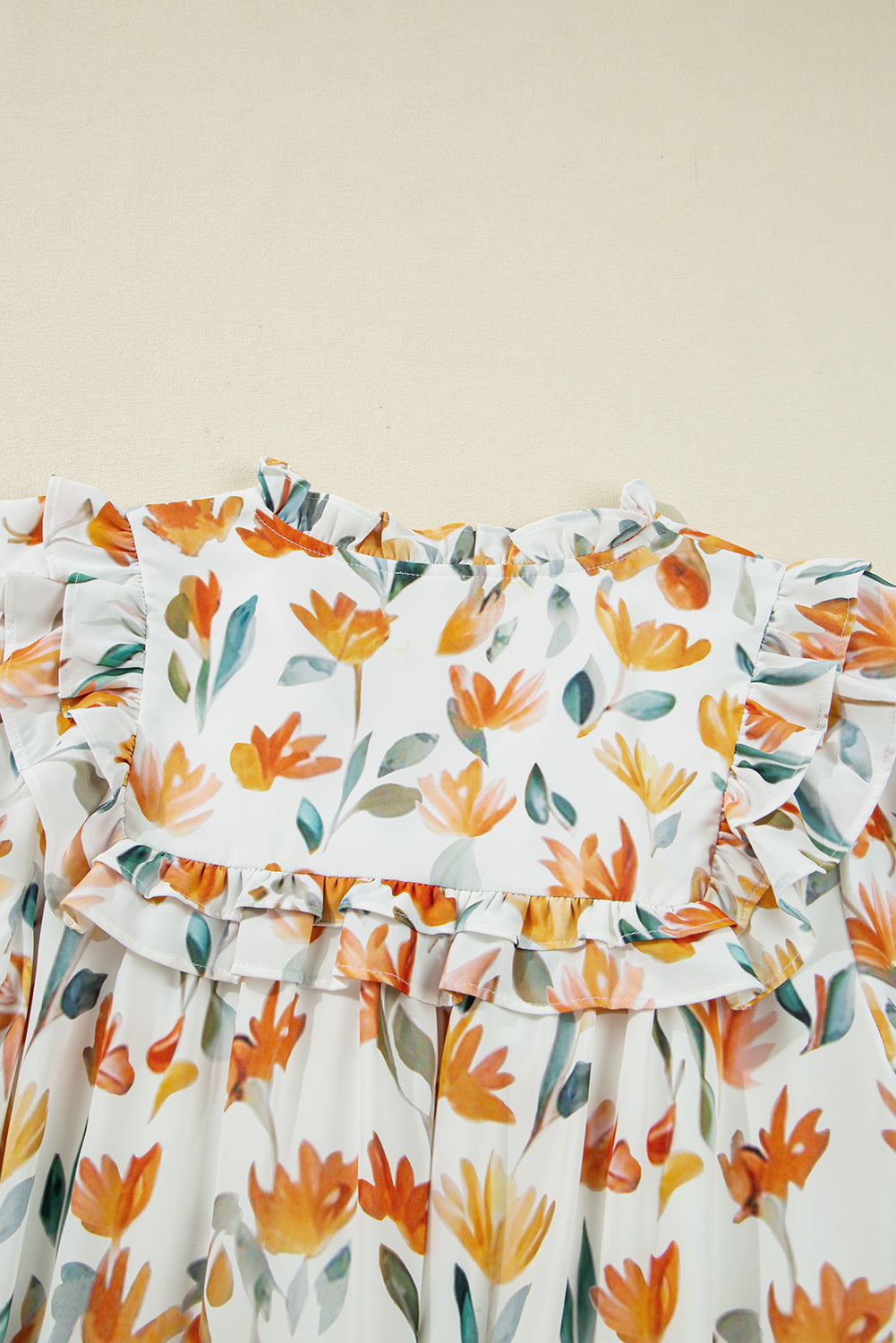 White floral dress with orange and green flower print and ruffled neckline