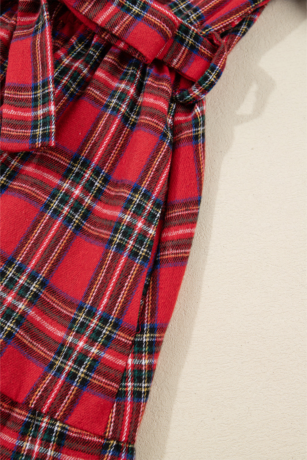 Close-up of red plaid fabric dress with belt, soft texture, tartan check pattern