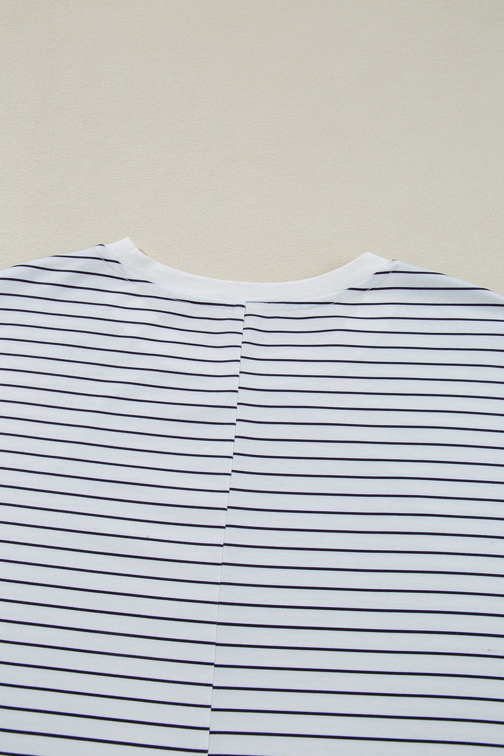 Close-up of white cotton t-shirt with thin horizontal black stripes, back view