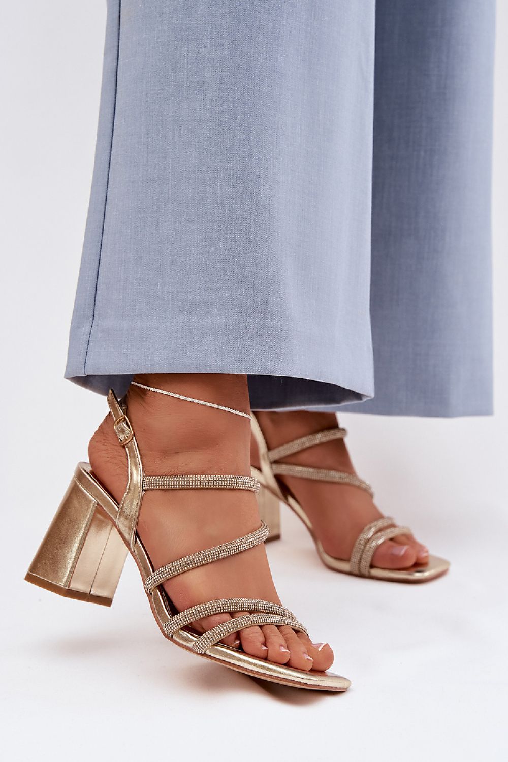 златисти дамски сандали на ток с камъни - изглед върху модел