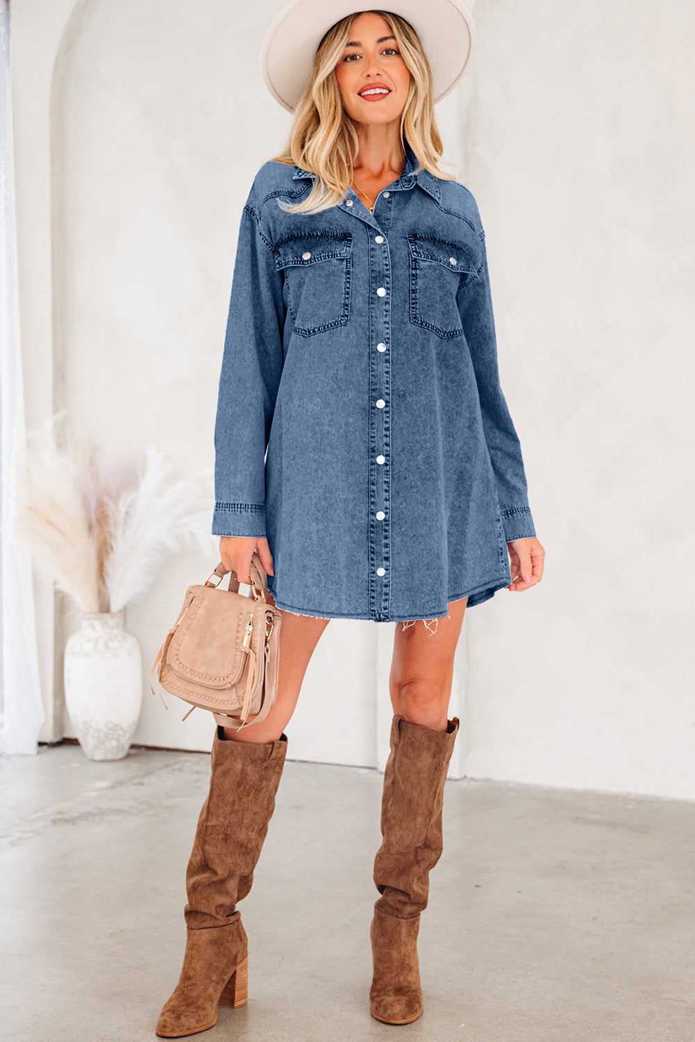 Woman in denim shirt dress, suede knee boots, beige hat, and tan handbag, casual chic style